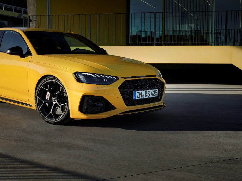 A yellow car parked in front of a building 
Description automatically generated